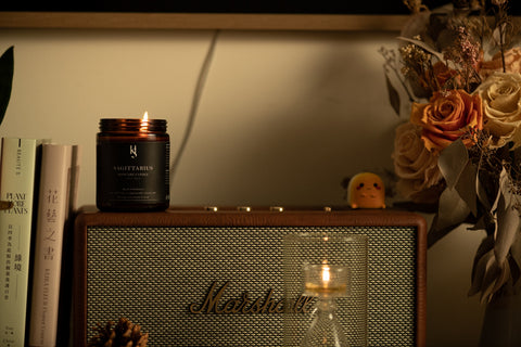 Wide shot of Sagittarius Scented Candle on Marshall Stanmore Action Speaker with plant and book decoration.