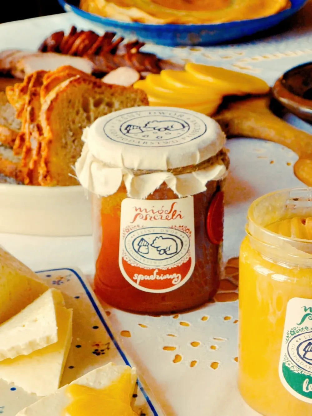 Miód spadziowy stojący na stole pośród przekąsek