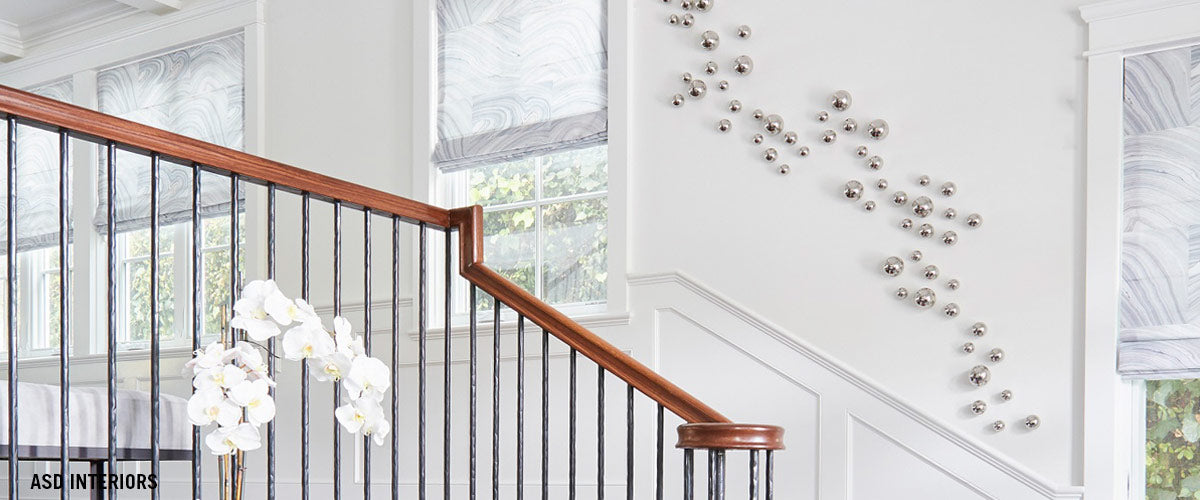 Silver stainless steel Orb Wall Play design on a descending staircase wall.