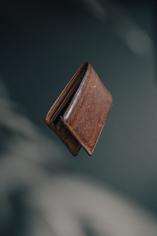 The Bicyclist Old Leather Bifold Leather Wallet Photograph tossed up in the air