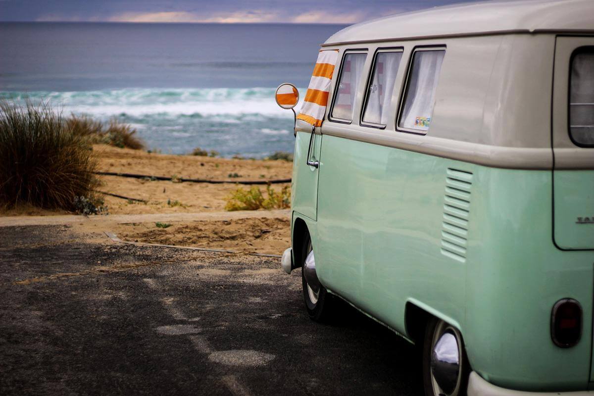 Vacances au bord de la mer en camping car Volkswagen vert type années 60