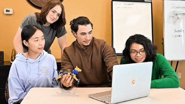 Teacher teaches robotics to students with Petoi robot dog Bittle