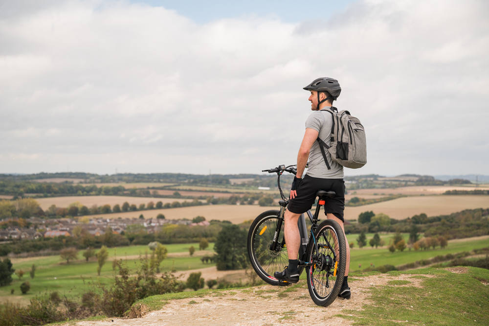 Ein Mann auf einem E-Bike fragt sich, wie hoch die Reichweite eines E-Bikes in freier Wildbahn weit weg von der Stadt ist