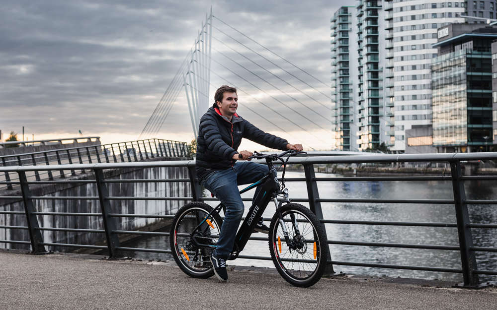 Een man rijdt met een elektrische fiets naar het werk