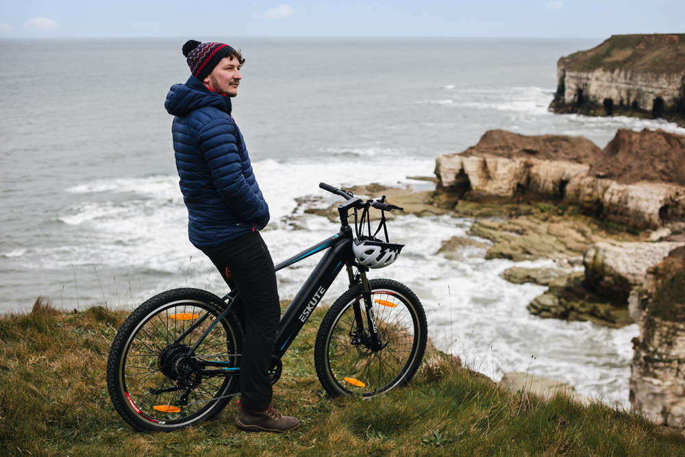 Ein Mann trägt beim E-Bike-Fahren eine dicke Mütze statt eines Helms