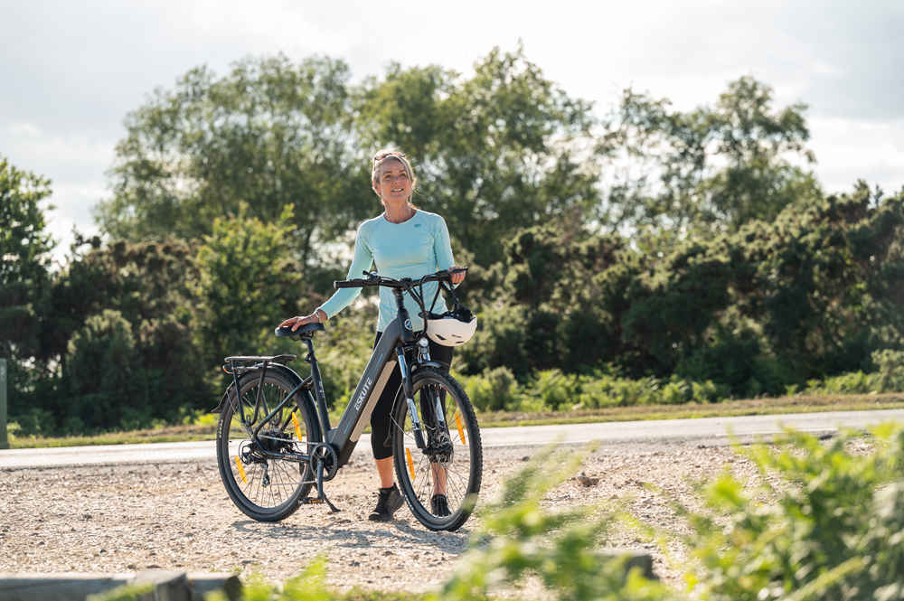 Eine Frau steht neben ihrem Polluno-Elektro-Hybridfahrrad