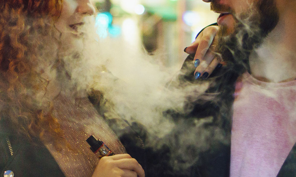 Two vapers smiling at each other