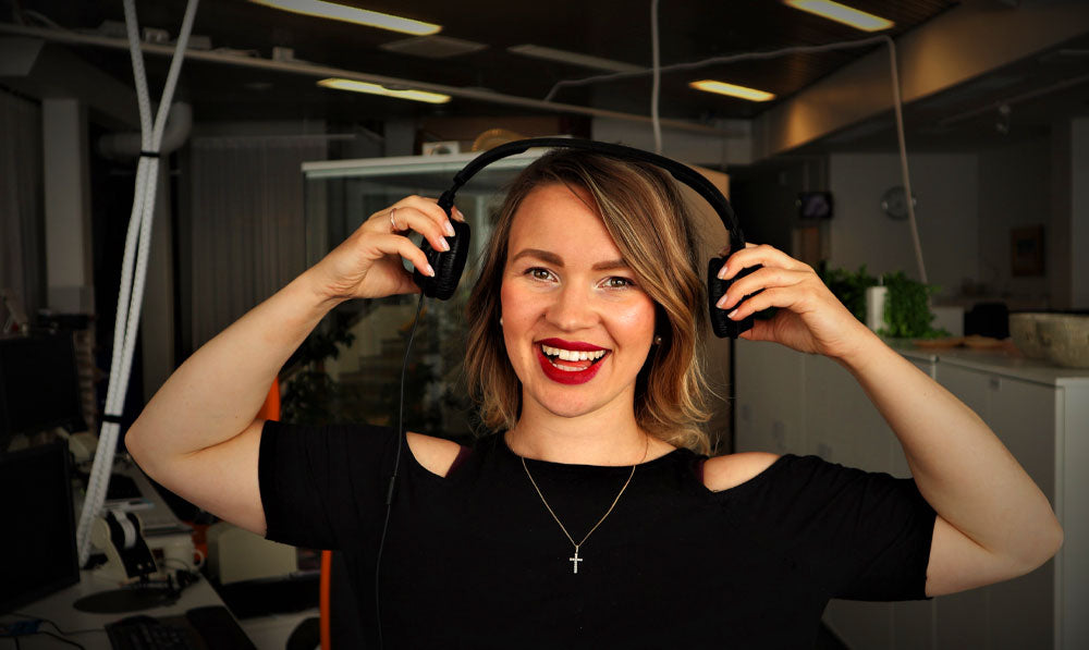 Mujer con auriculares dentro del estudio de podcast