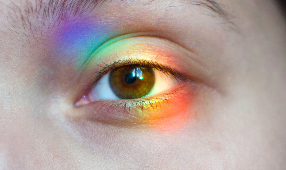 Brown eye under natural light with rainbow