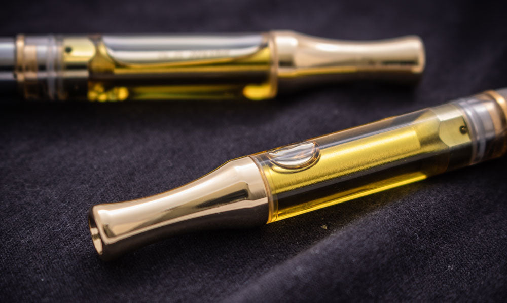 Two oil cartridges resting side by side on soft surface