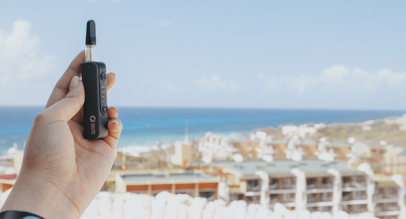 Mujer sosteniendo Sutra Stik 650 afuera cerca de la playa