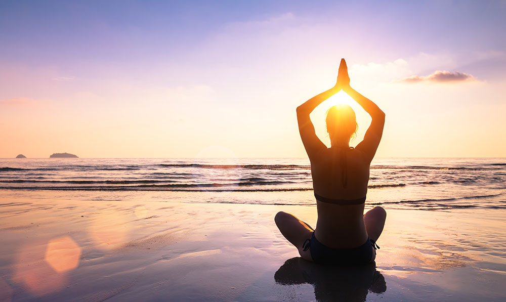 Woman doing yoga on beach