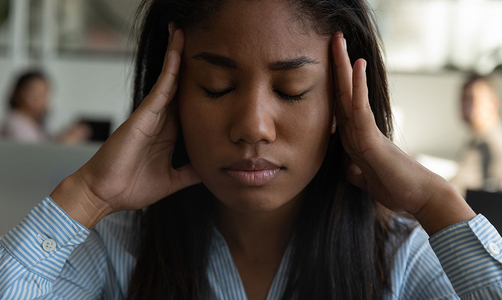 woman with headache inside office