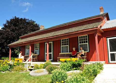 An exterior view of the Rose House Museum which is a red house with a porch