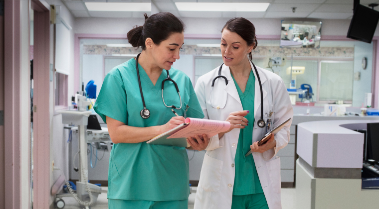 two PMHNP nurses looking at a patient chart in a hospital setting