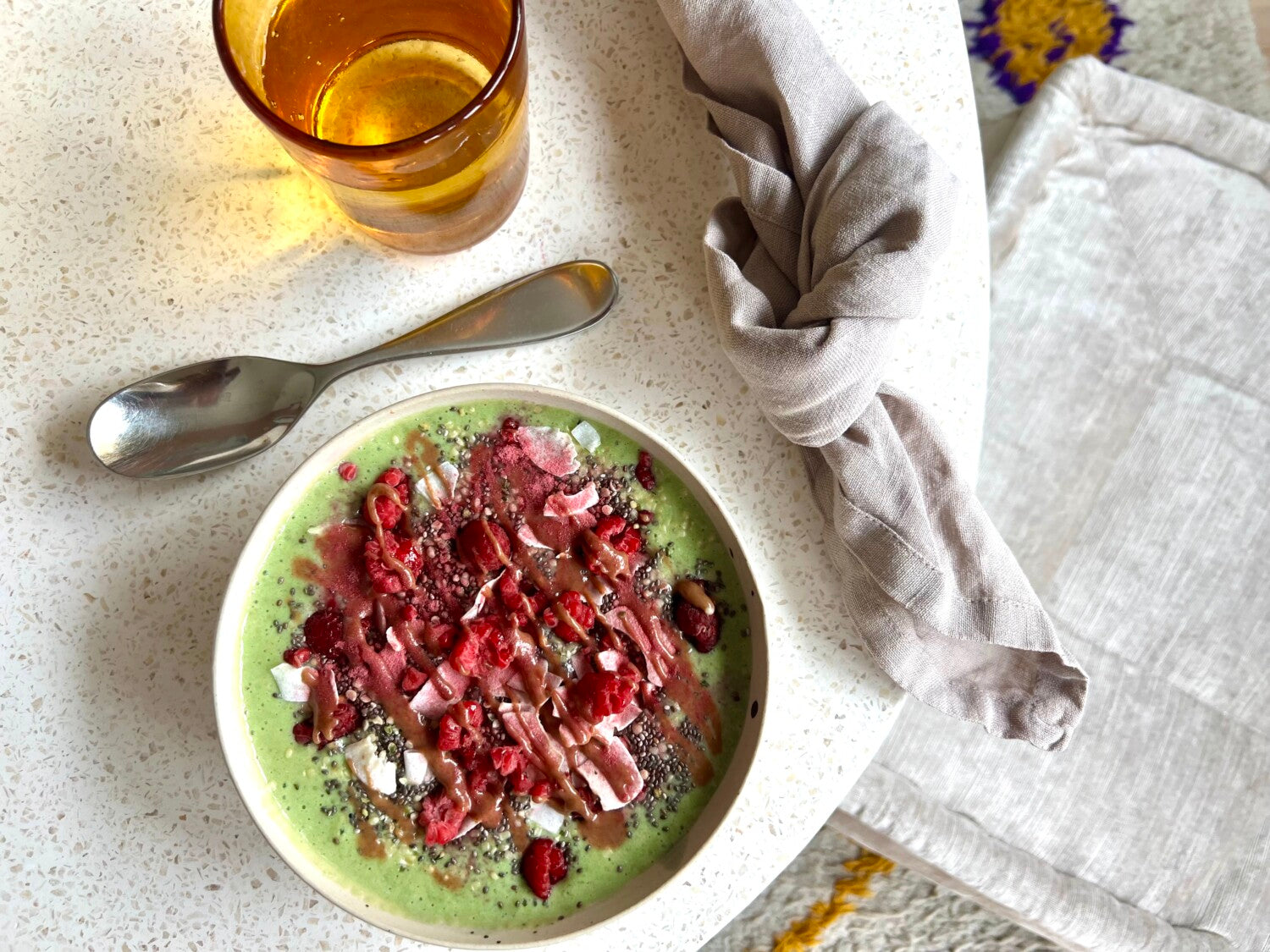 green smoothie bowl on a stone table