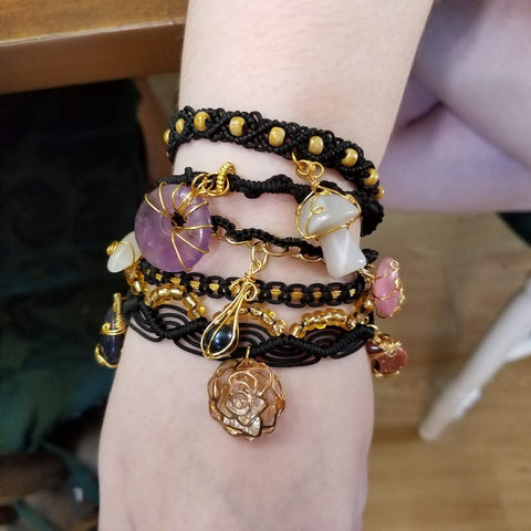 Layered macrame bracelet with assorted quartz charms including a mushroom and moon