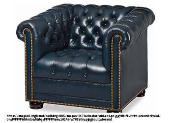 A photo of a Chesterfield chair, which is an upholstered armchair with a distinctive deep button tufting and rolled arms that are the same height as the backrest. The chair may have a traditional design with rich leather upholstery and nailhead trim or a more modern look with colorful velvet fabric and sleek metal legs. The photo may show the chair in a variety of settings, such as a library, office, or living room.