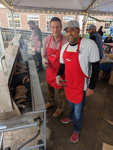 Two AIS dads working the sausage grill at the Christmas Market