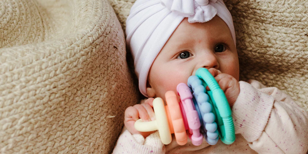 Baby with a Jellystone Rainbow Stacker and Teether. Belly Beyond.