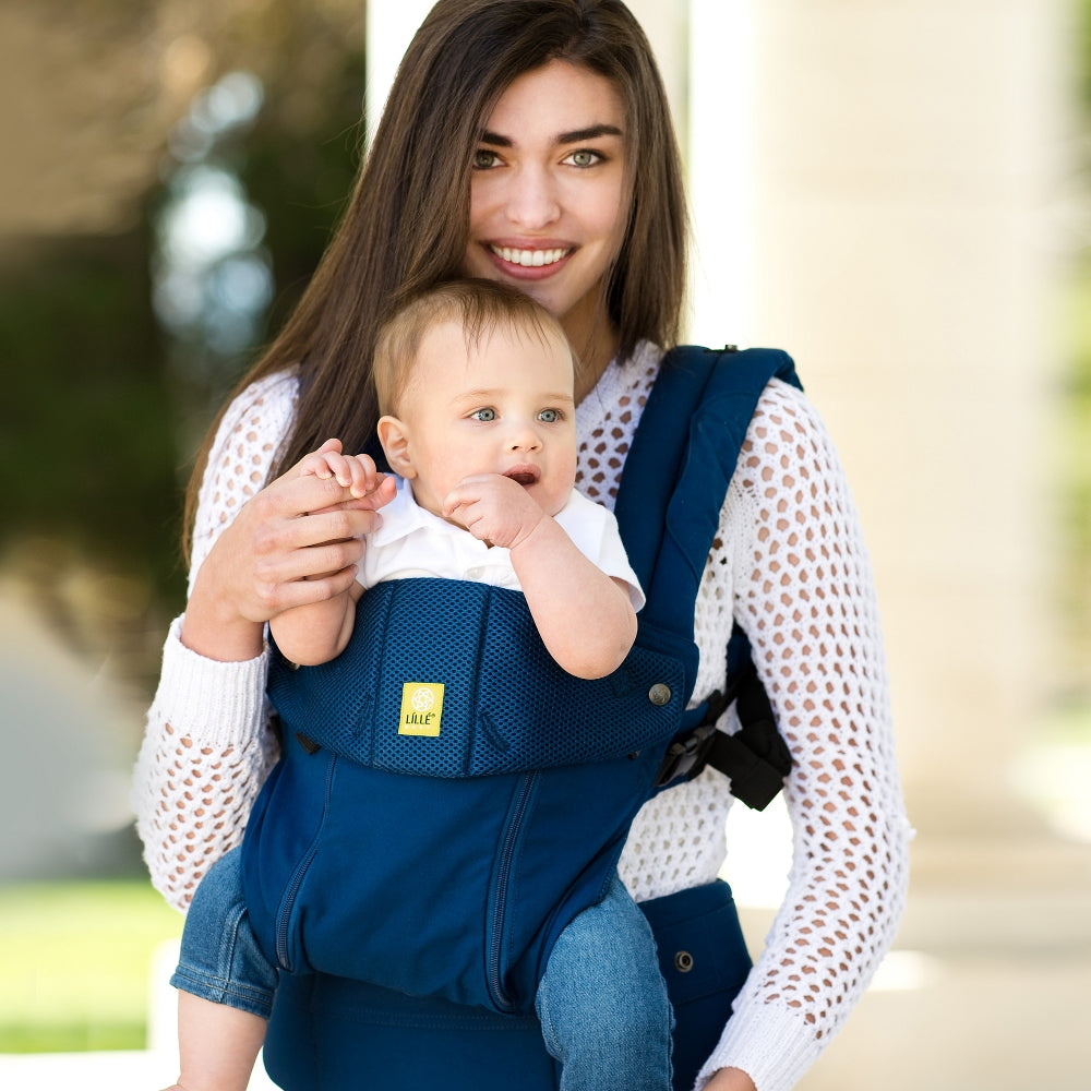Mother and baby in a LILLEbaby carrier, using the front outward-facing position. Babywearing Series. Belly Beyond.