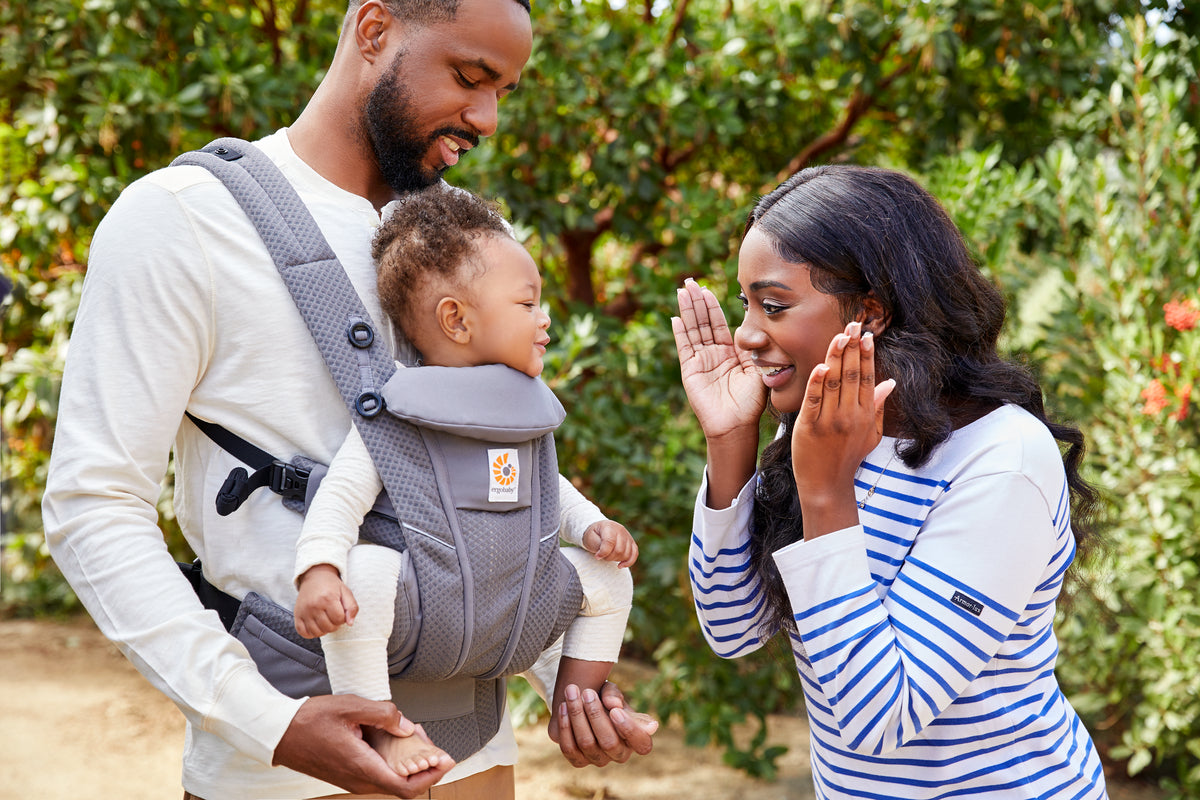 Mum, Dad and baby out and about in the Ergobaby Omni Breeze, in the front outward-facing position