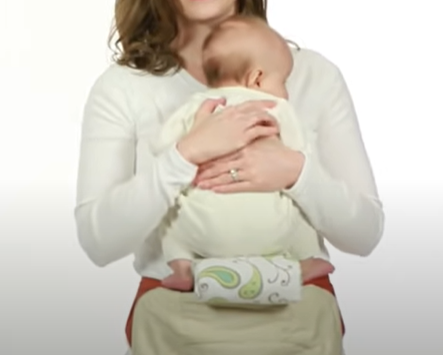 Roll up a blanket to create your own infant pillow for a newborn carrying style, front-fetal position. 