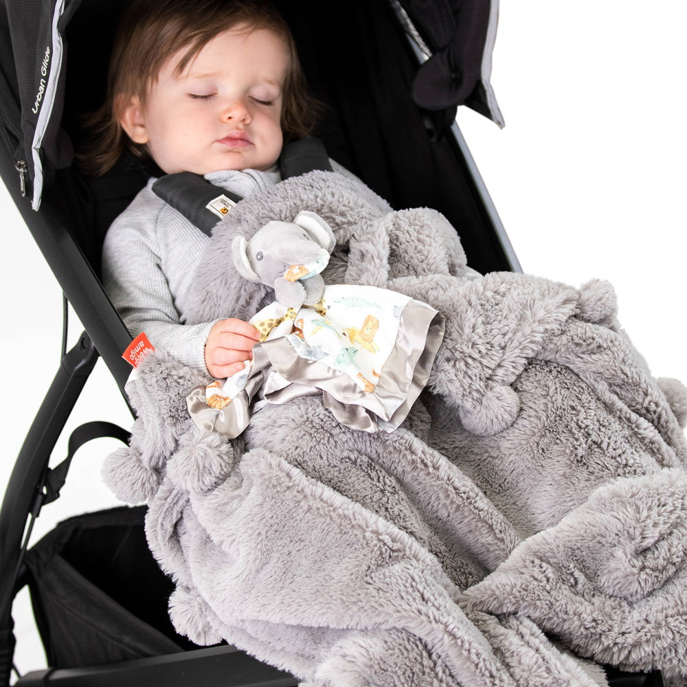 Baby with Pom Pom Blanket sleeping in a stroller