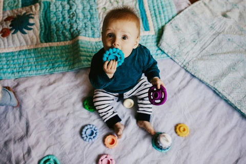 Baby teething with Jellystone teether and toy. Belly Beyond.