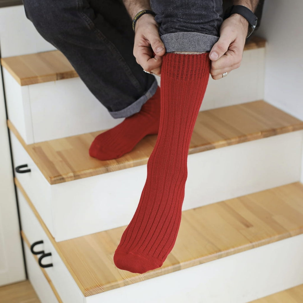 person on stairs stretching red socks