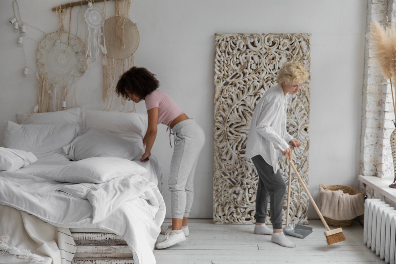 Two women cleaning the bedroom
