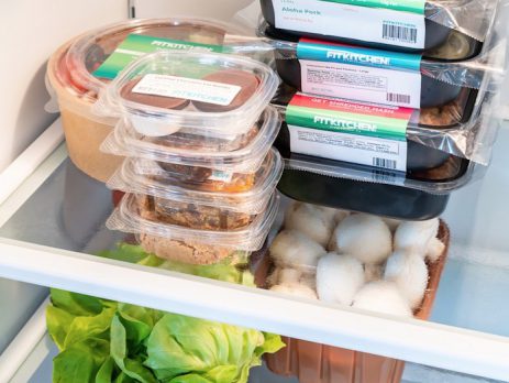Prepped meal kits stacked in a refrigerator. 