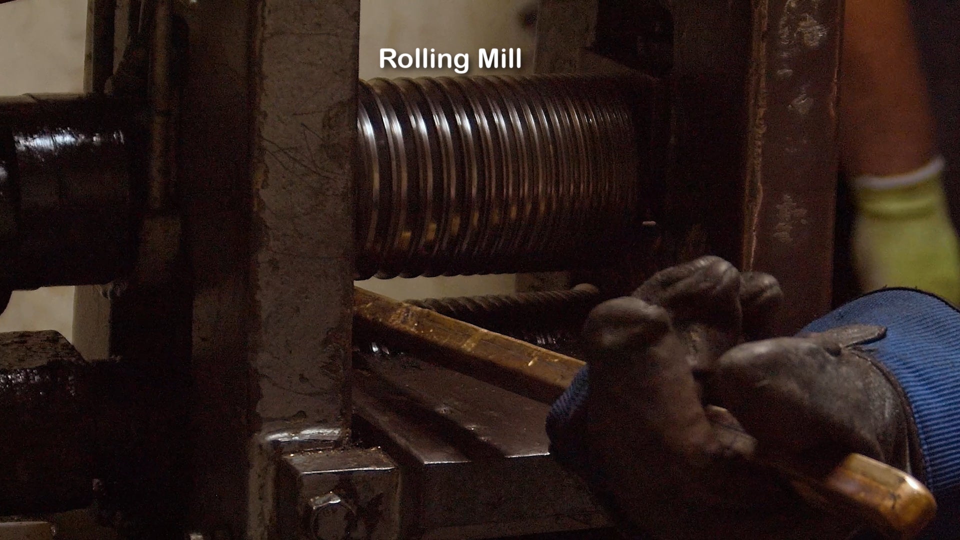 passing gold bar through rolling mill