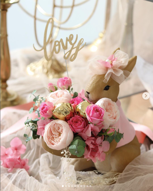 A bouquet of pink and white flowers with a stuffed bunny