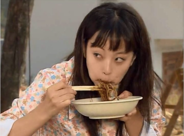 A woman eating black bean noodles