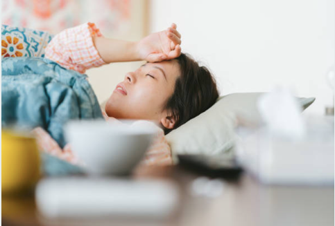 A young woman in bed with a fever