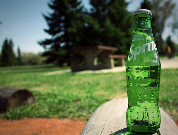 A bottle of Sprite on a picnic table