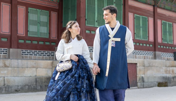 A white man and woman wearing blue and white hanboks