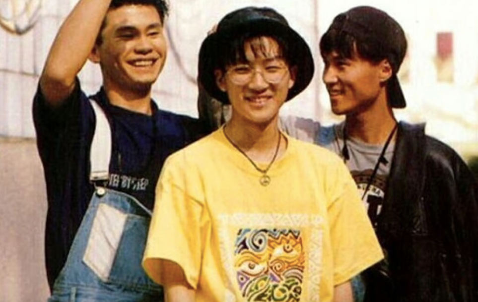 A man in overalls, a man with yellow T-shirt and hat, and man with backwards baseball cap