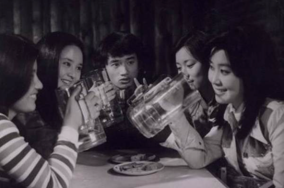 Five college students drinking pints of beer