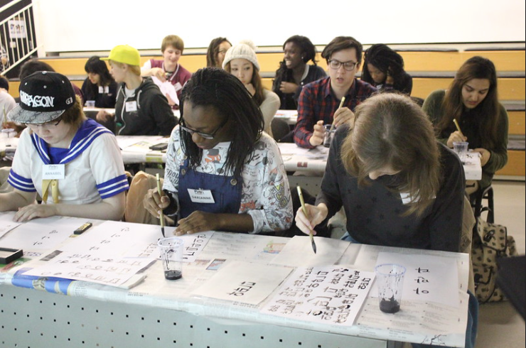 Students learning to write Hangul with ink and brush