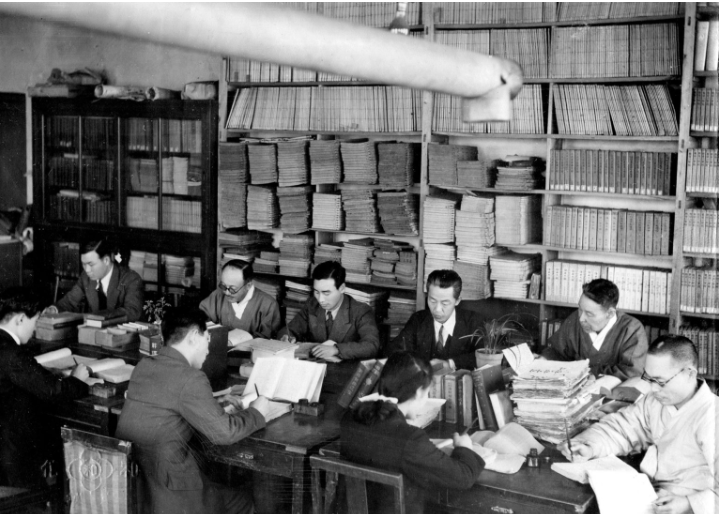 Korean scholars writing in a basement library