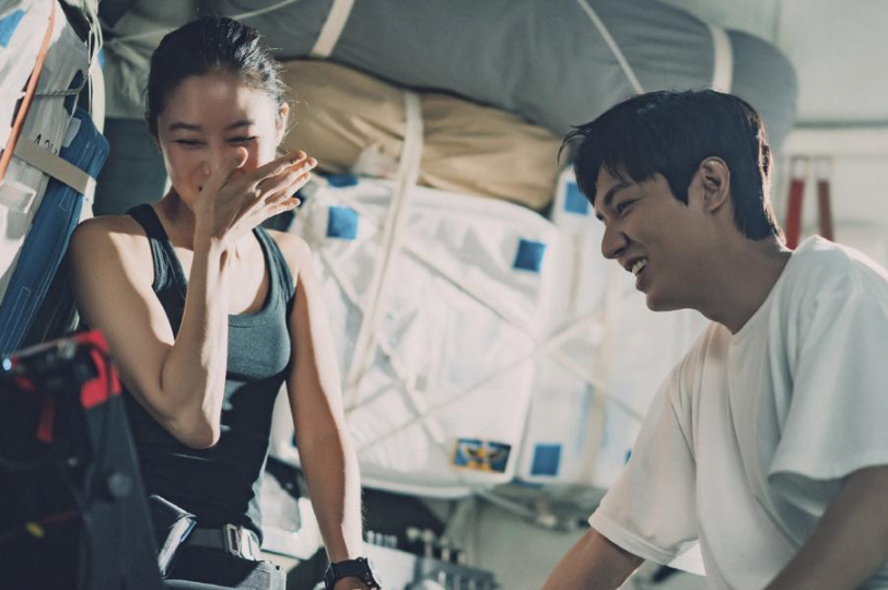 A woman in a gray tank and a man in a white T-shirt laughing together