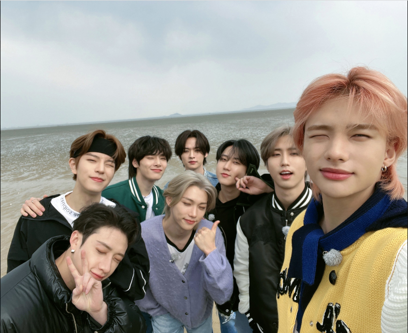 Stray Kids taking a picture on the beach