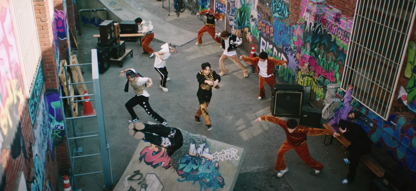 Stray Kids in a graffiti-lined alleyway