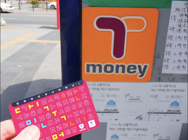 Hand holding T-Money card next to T-Money machine