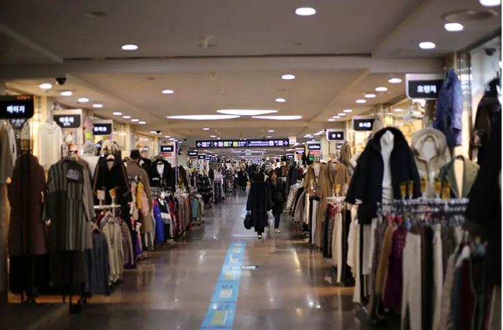 Aisle of Goto Mall with clothing racks visible and crowd in background