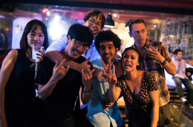 Six people holding drinks in a bar in Itaewon