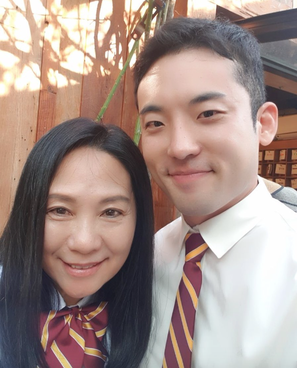 A man wearing white shirt and red-and-yellow striped tie and a woman wearing similar colored scarf