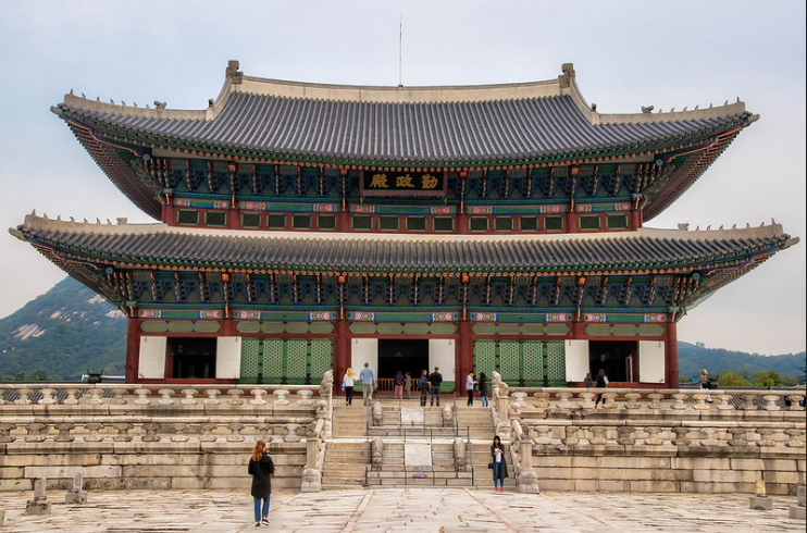 Gyeongbokgung Palace with a person in black standing at the foot of the stairs